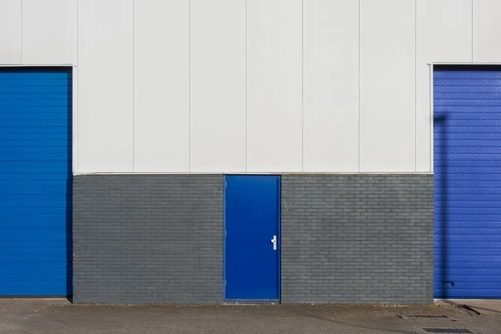Blue commercial doors and a pass door on a business building