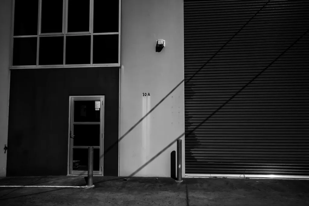 Steel garage door sections next to a glass entry