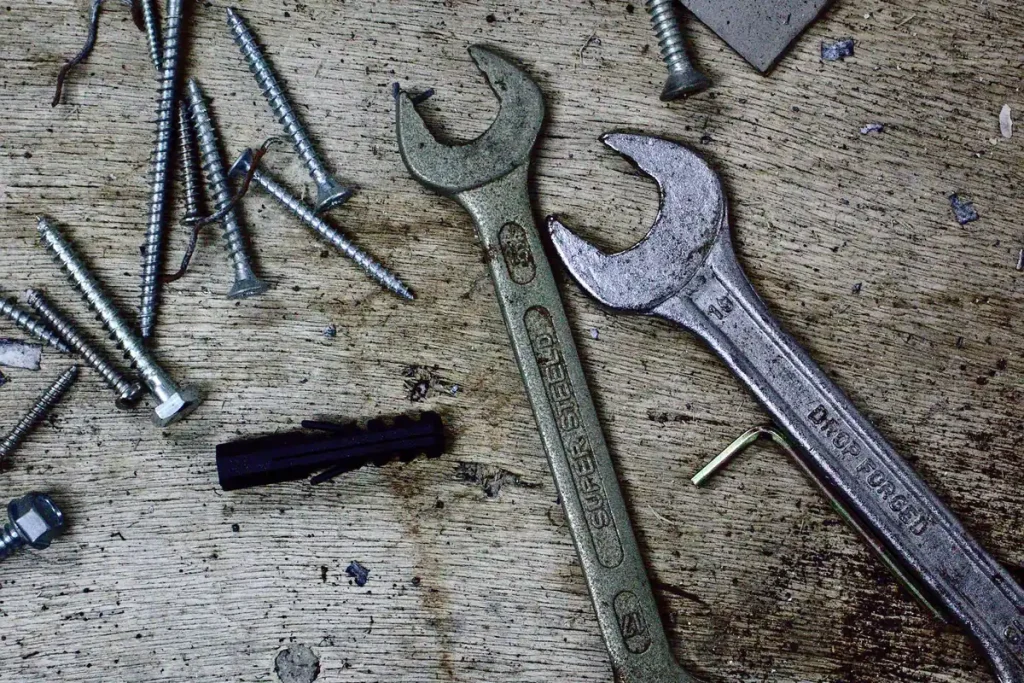 Wrenches and hardware used to replace garage door cables and drums