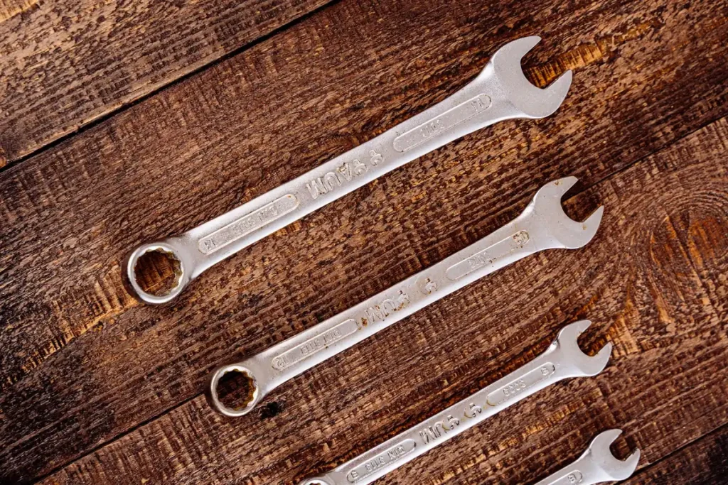 Combination wrenches on a wood bench for garage door maintenance